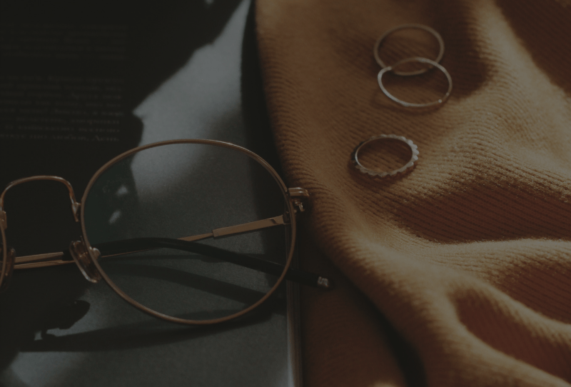 Reading glasses and gold rings sitting on laptop and cute mustard shirt